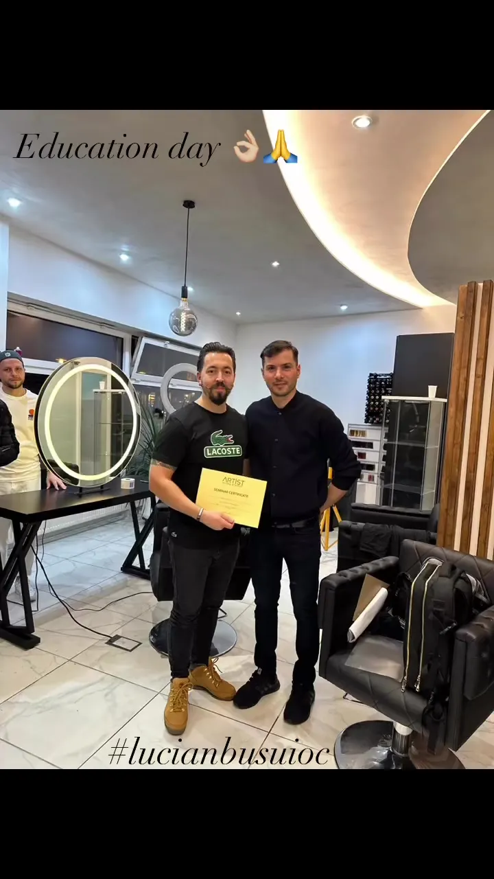 Alin alături de un invitat, ținând certificatul seminarului ARTIST în interiorul salonului