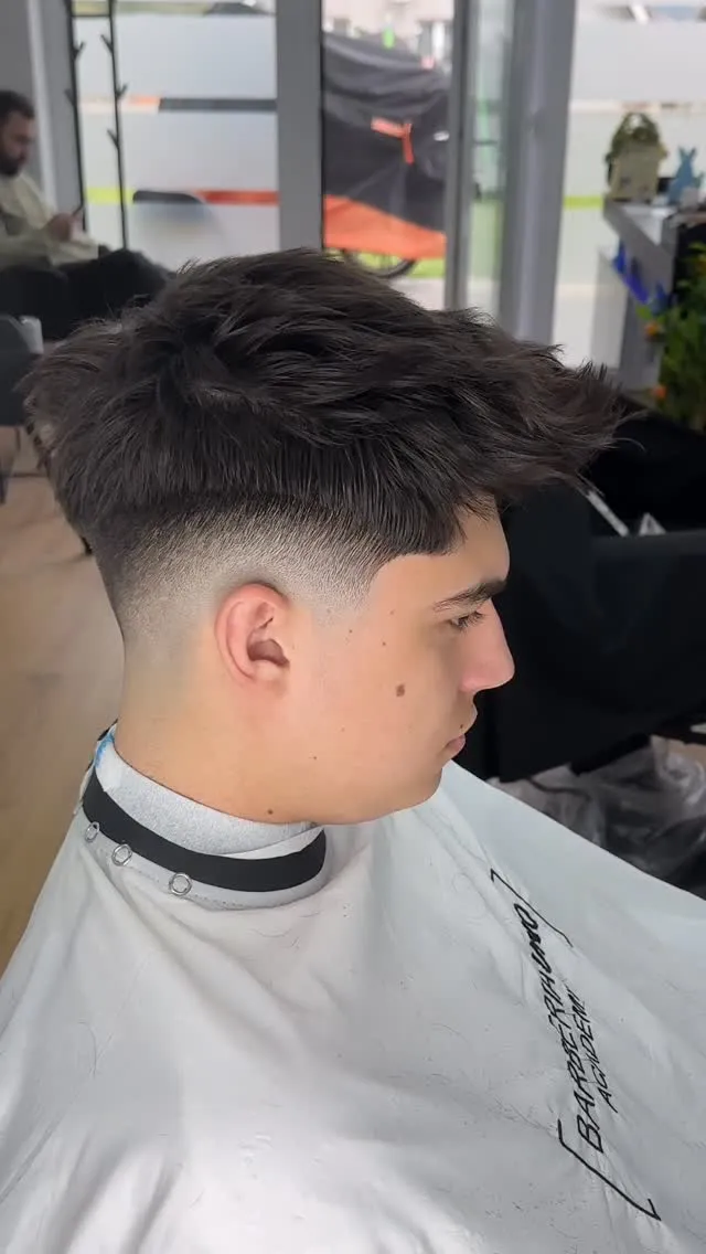 Client al BARBERIA UNO cu tunsoare textured-top mid-fade, finalizată de Alin